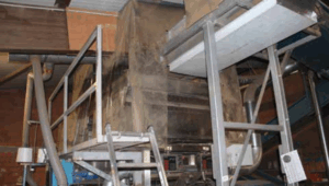 Eine Staubschutzplane um die Verarbeitungsmaschine soll die Staubbildung während der Kartoffelverarbeitung begrenzen.