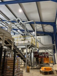 Windshifting and extraction pipes above the infeed line with sorting machine in the potato line.