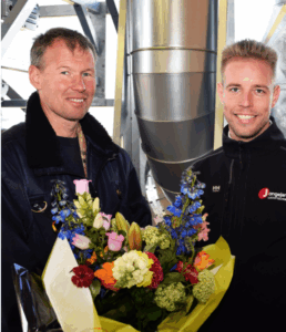 Pennings receives a bouquet of flowers upon delivery of the thousandth cyclone installation from Jongejans Luchttechniek.