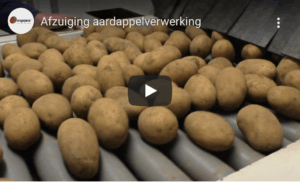 Potatoes move across a processing line where extraction is used to remove dust.