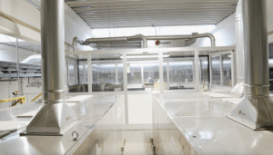 Espace intérieur avec technologie de surpression et d'extraction Jongejans, comprenant des conduits d'air métalliques au-dessus d'une zone de tri fermée.