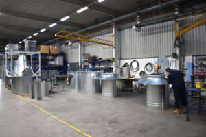 An employee in the workshop of Jongejans Luchttechniek works on metal parts for cyclone installations.