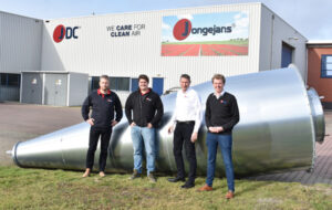 New directors of Jongejans Luchttechniek stand in front of a large cyclone installation outside the company premises.