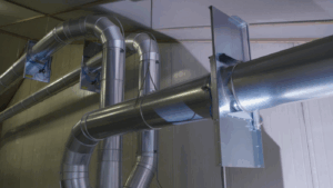 Metallene Luftkanäle mit Krümmungen und Ventilen als Teil des Staubabsaugungssystems.