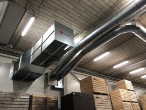 Large air ducts and a filter unit from Jongejans Luchttechniek extract and filter the air flow for onion processing.