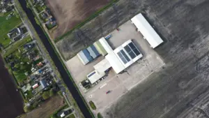 Aerial photograph of the Mencke Landbouw company premises with barns and surrounding fields.