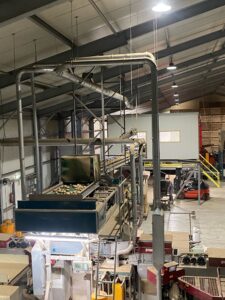 Gesamtansicht der Verarbeitungshalle mit Kartoffelförderband und komplettem Absaugsystem an der Decke.